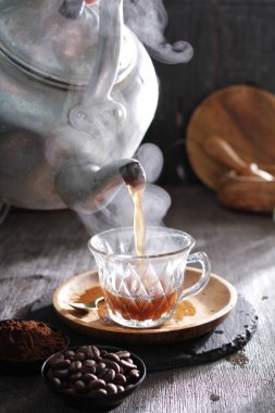 Bir çaydanlık fincana çay dolduruyor.