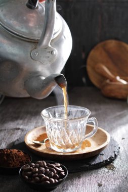 Bir çaydanlık fincana çay dolduruyor.