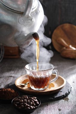 Bir çaydanlık fincana çay dolduruyor.