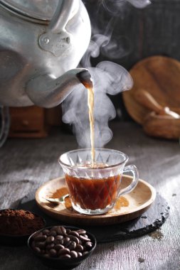 Bir çaydanlık fincana çay dolduruyor.