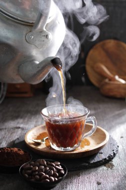 Bir çaydanlık fincana çay dolduruyor.