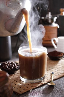 Bardağa doldurulan bir fincan kahve.