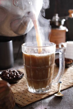 Bir fincan kahve, kaşık ve kaşık paspasın üzerinde dinleniyor.