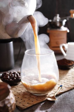 Biri bardağa kahve dolduruyor.