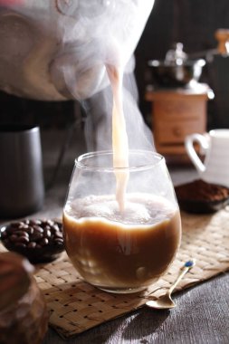 Biri bardağa kahve dolduruyor.