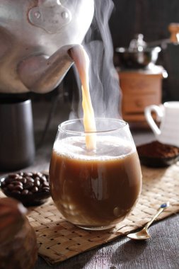 Bardağa doldurulan bir fincan kahve.