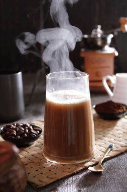 Masanın üzerinde dumanı tüten bir fincan kahve.