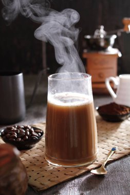 Masanın üzerinde dumanı tüten bir fincan kahve.