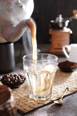 Biri bardağa kahve dolduruyor.
