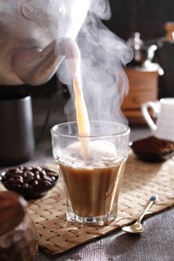 Bardağa doldurulan bir fincan kahve.