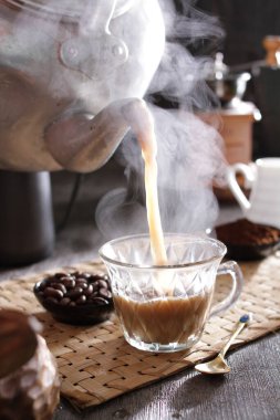 Masanın üzerinde dumanı tüten bir fincan kahve.