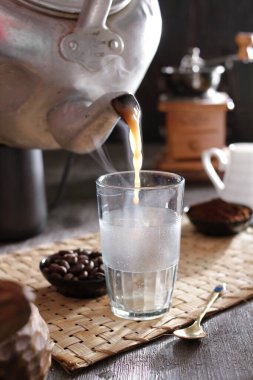 Bir insan bardağa içki dolduruyor.