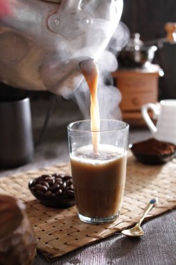 Biri bardağa kahve dolduruyor.