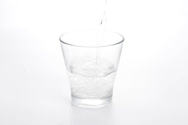 Bardağa bir bardak su dökülüyor.