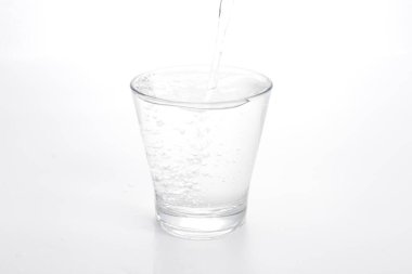 Bardağa bir bardak su dökülüyor.