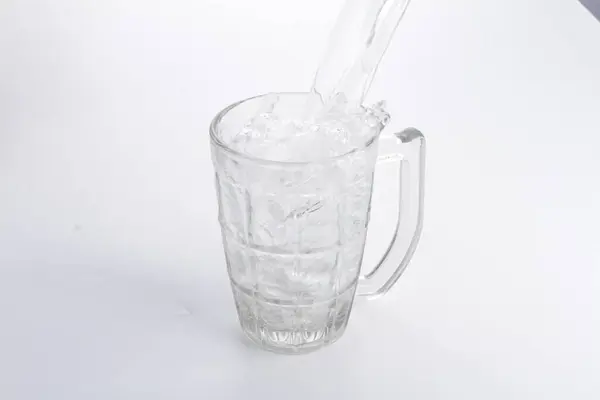 a pitcher of water with a straw being poured into it