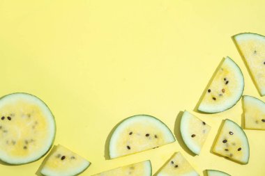 Daire şeklinde dizilmiş karpuz dilimleriyle sarı bir zemin.