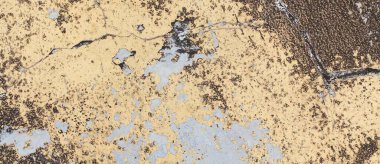 Çatlak yüzeyi olan sarı ve mavi bir duvar.