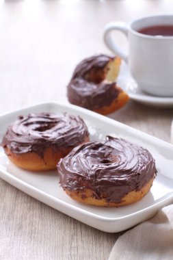 Beyaz tabakta iki çikolatalı donut.