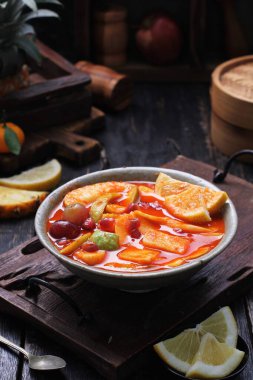 Bir kase çorba, meyve ve kaşık.