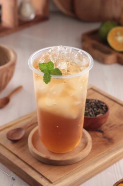Ahşap masada cam kavanozda buzlu çay.