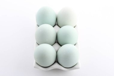 Beyaz arka plandaki kutuda tavuk yumurtası var.