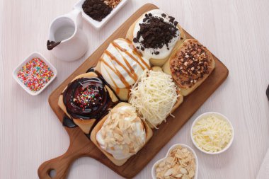 Kremalı ve fındıklı çikolatalı çörekler ahşap masada.