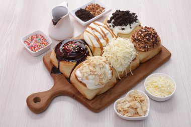 Tahta masada çeşitli ekmek ve çörekler var.