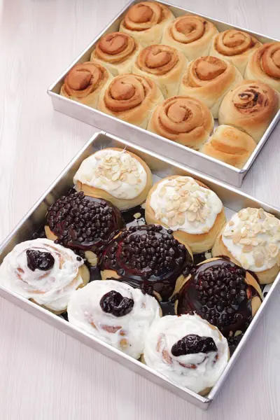 Beyaz arkaplanda çeşitli lezzetli çörekler olan tepsi