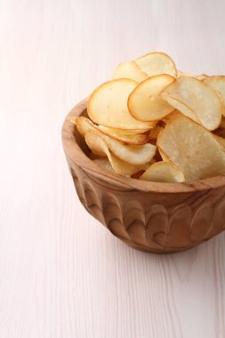 Tahta arka planda patates cipsi