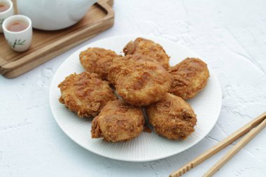 Soslu tavuk nugget ve beyaz tabakta baharat.