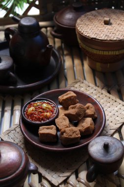 Baharatlı ve lezzetli kızarmış tofu sarımsaklı biber sosu ve petai ile servis edilir.