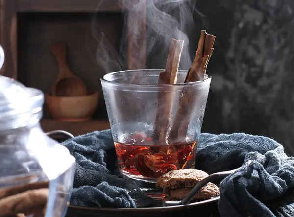 Ένα Ποτήρι Κόκκινο Ζεστό Τσάι Πάγο Και Κανέλα Ξύλινο Τραπέζι — Φωτογραφία Αρχείου