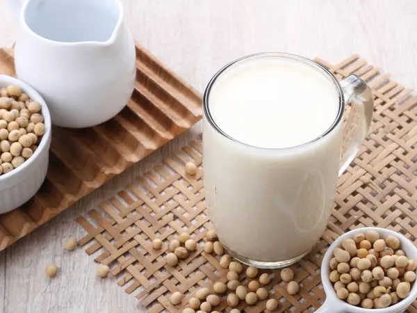 soy milk with soybeans on a wooden table. top view