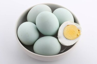 Beyaz arka planda mavi tabakta taze tavuk yumurtası.