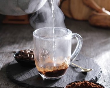 kahve fincanı ve masada kahve çekirdekleri