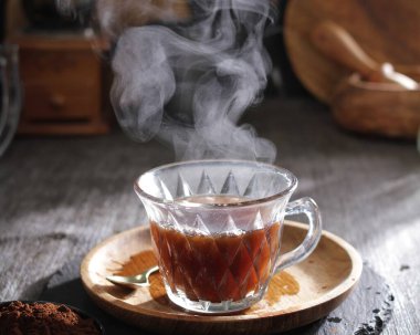 Tahta bir masanın üzerinde bir fincan sade kahve.