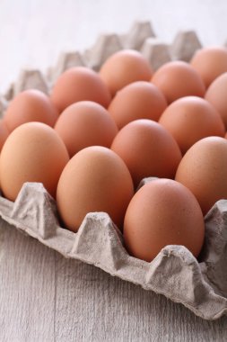 Tahta masadaki karton kutuda taze yumurtalar..