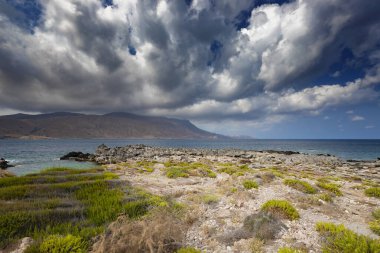 Yunanistan 'ın Girit adasının kıyısında muhteşem bulutlar ve mavi gökyüzü. Deniz manzarası. Kissamos 'taki Rocky Sahili. Rocky Dağları. Resimli bir manzara. Yunan adası. Yunan manzaraları. Doğa arkaplanı.