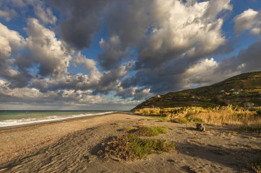 Yunan adası Evia kıyısı ve güneşli bir günde güzel deniz manzarası fantastik bulutlarla mavi gökyüzü, yatay çerçeve