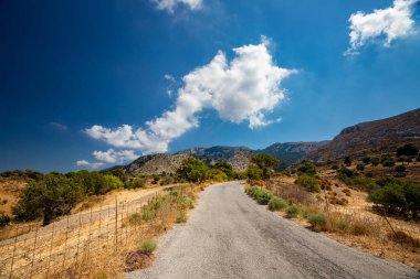 Arka planda mavi gökyüzü olan güzel dağ yolu