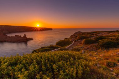 Denizin üzerinde gün batımı, güzel İspanyol adası Menorca 'nın manzarası, açık hava çekimi.
