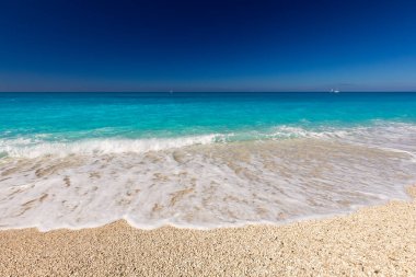 Beyaz kum ve mavi gökyüzü arkaplanlı güzel deniz plajı