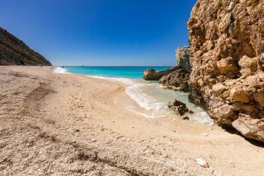 Megali Petra beach, holiday seascape overlooking a wild beach with rocks in the azure Ionian Sea, on the Greek island of Lefkada, background for design, wallpaper clipart