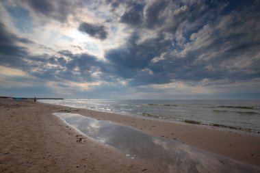 Baltık deniz plajı Güzel beyaz kumlu, mavi gökyüzü, bulutlu.
