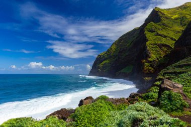 Uçurumlarla, plajlarla ve okyanuslarla dolu kıyı manzarası mavi gökyüzü altında, Achadas da Cruz, Madeira