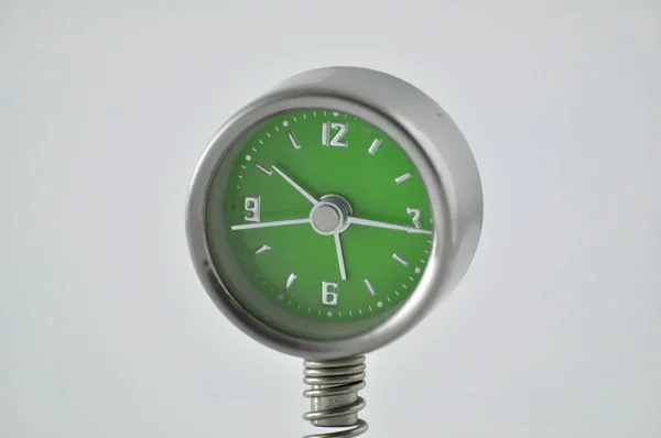 緑の背景に目覚まし時計のクローズアップショット — ストック写真