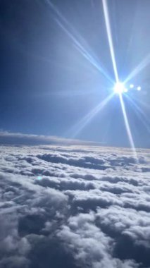 Air Canada uçuşu, kanat, motor ve bulut hareketlerini bir pencere oturağından yakalıyor. Aşağıda, mavi ve yeşil tonlarda toprak ve denizin çarpıcı manzarası görülebilir. Seyahat içeriği için ideal.