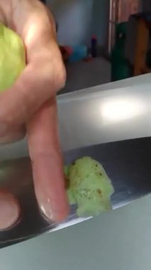 Bir guava dilimleyip doğramak. Guava kesmek için mutfak bıçağı kullanma becerisi. Mutfak masasında sebze yemek..