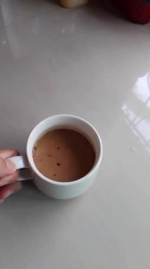 İçmek üzereymiş gibi beyaz bir fincan aldım, ama sonra orijinal yerine geri yerleştirdim..